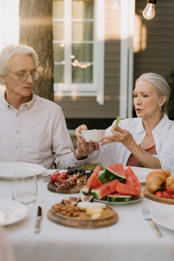 Un couple de séniors discutent devant une table pendant le déjeuner