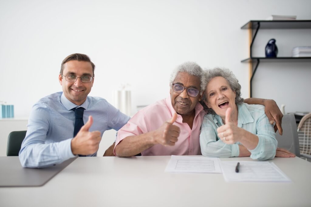 Un couple de séniors souriants avec un coach.