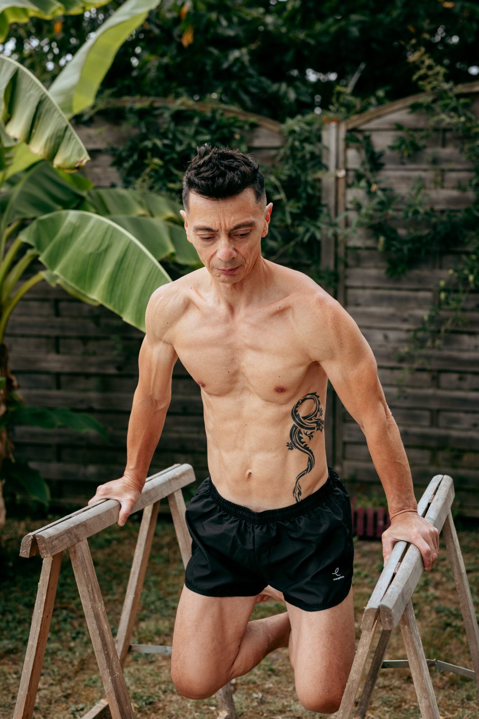 Bruno réalise des dips sur tréteaux dans son jardin