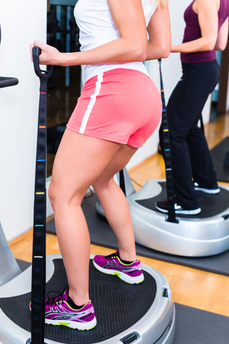 jeune femme qui réalise un exercice sur une plateforme vibrante