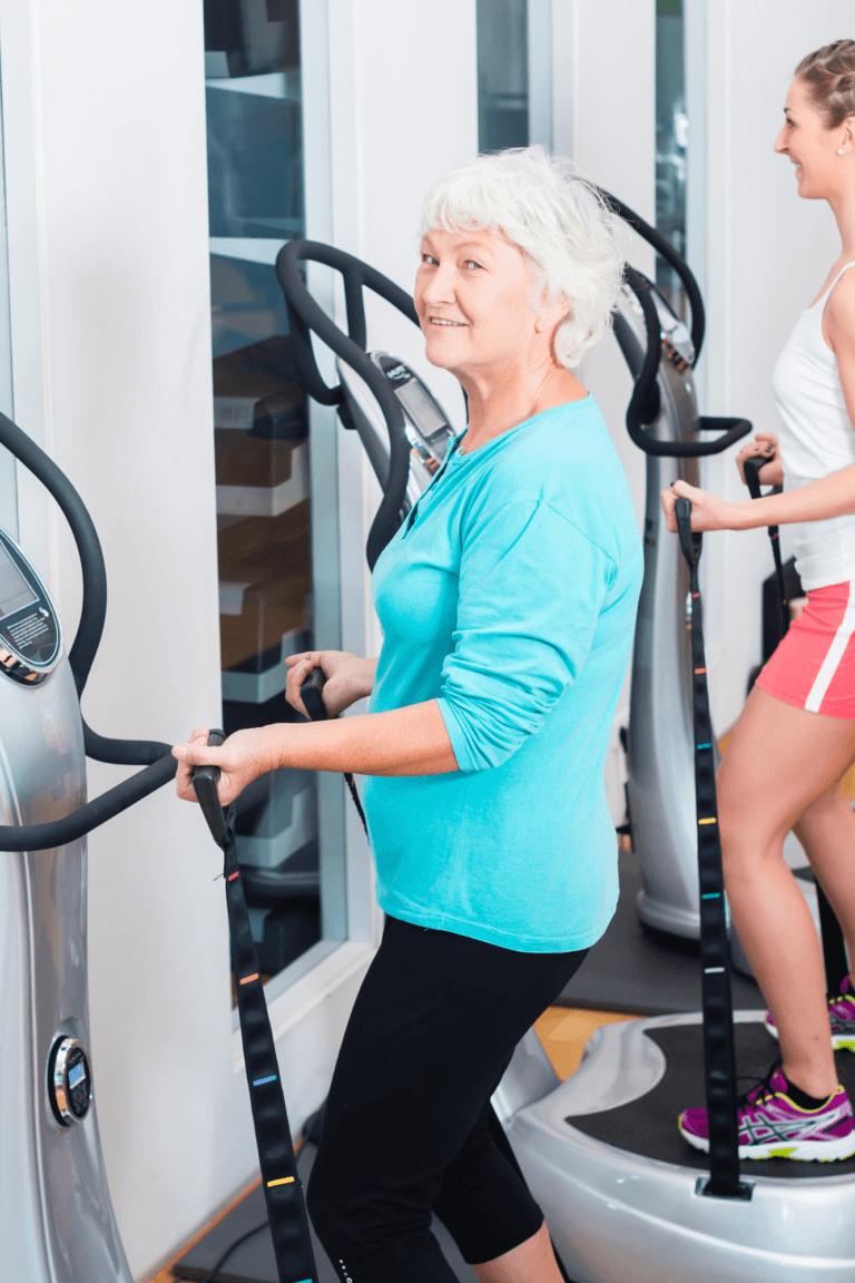 une femme agêe pratique un exercice de fitness sur une plate forme vibrante