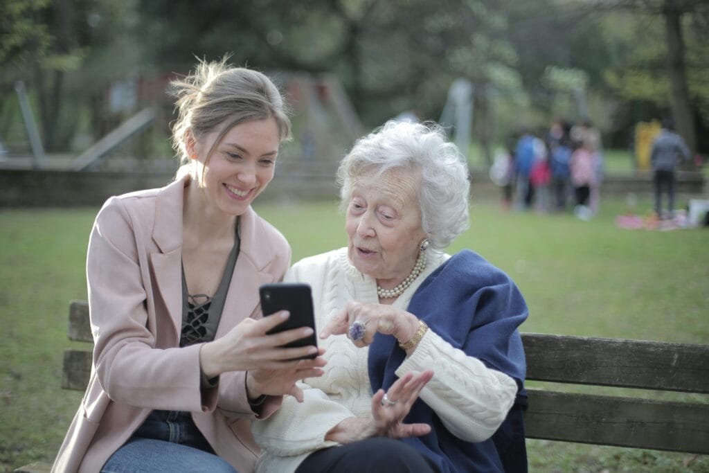 Une jeune femme montre des photos à une personne âgée